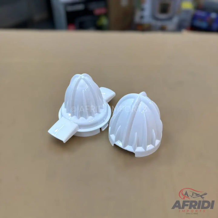 Two white plastic manual juicer reamers.