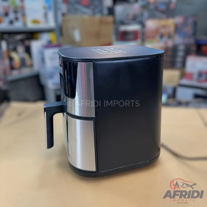Black and silver air fryer with a handle.