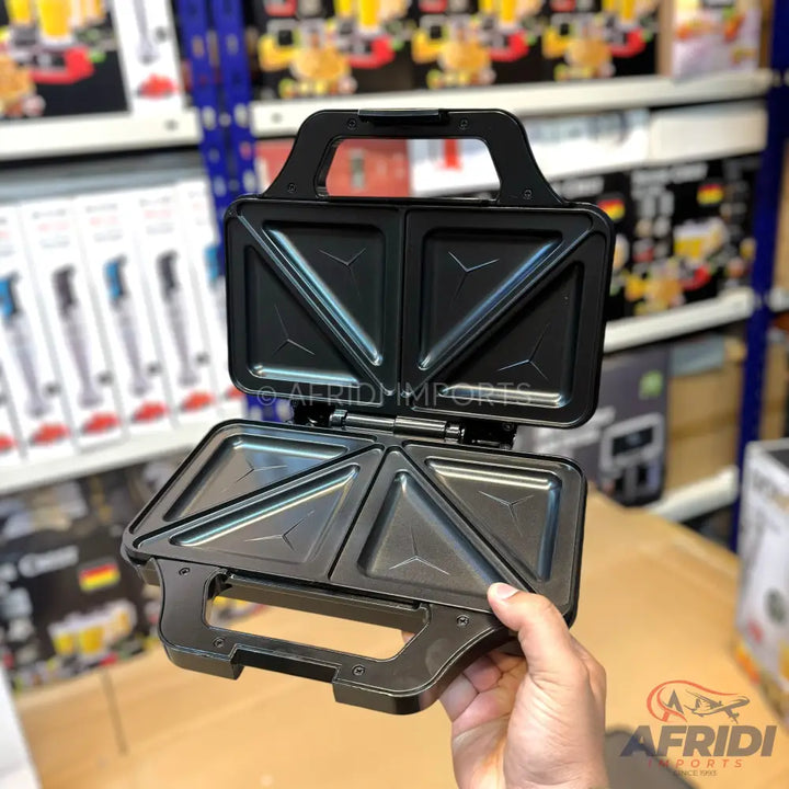 Opened black electric sandwich maker with non-stick triangular plates.