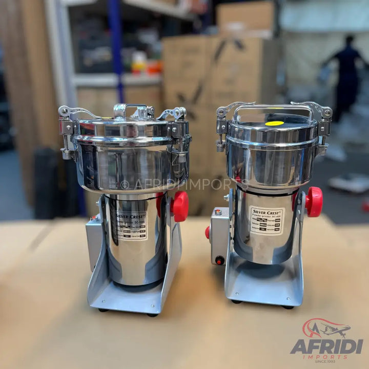 Two stainless steel commercial spice grinders with red power buttons.