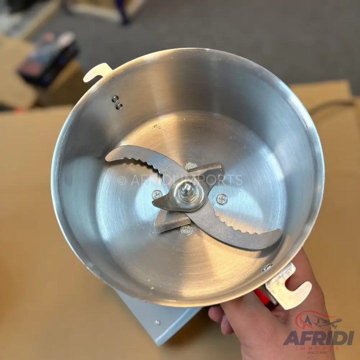 A shiny metal grinder with a two-bladed serrated cutting mechanism.