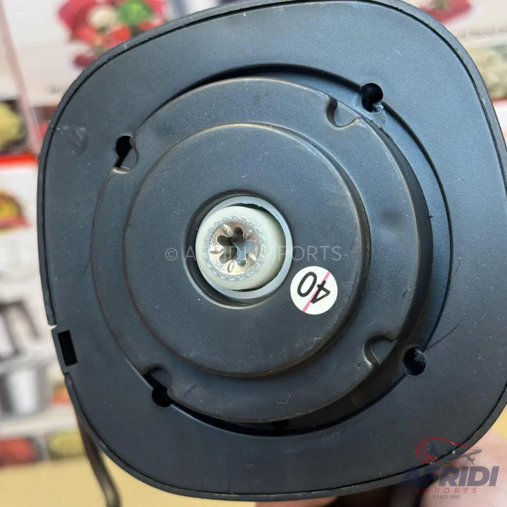 The underside of a black electronic device with a central screw and a ’40’’ sticker.