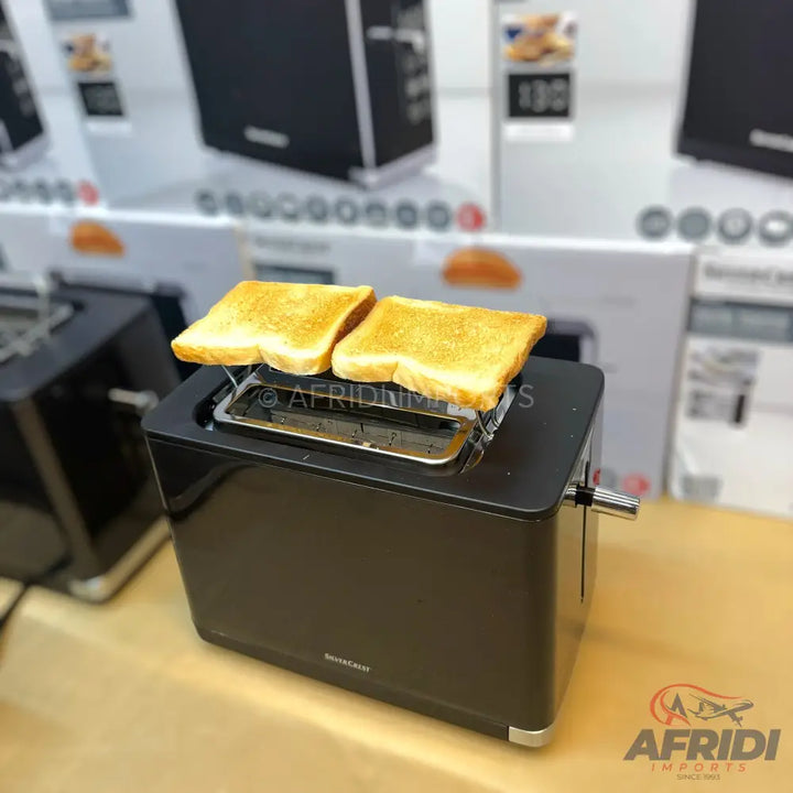 A sleek, black two-slice toaster with two pieces of golden brown toast resting on top.