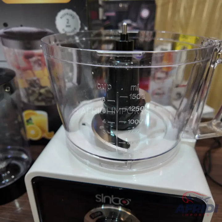 White and black food processor with a clear plastic bowl and a visible blade.