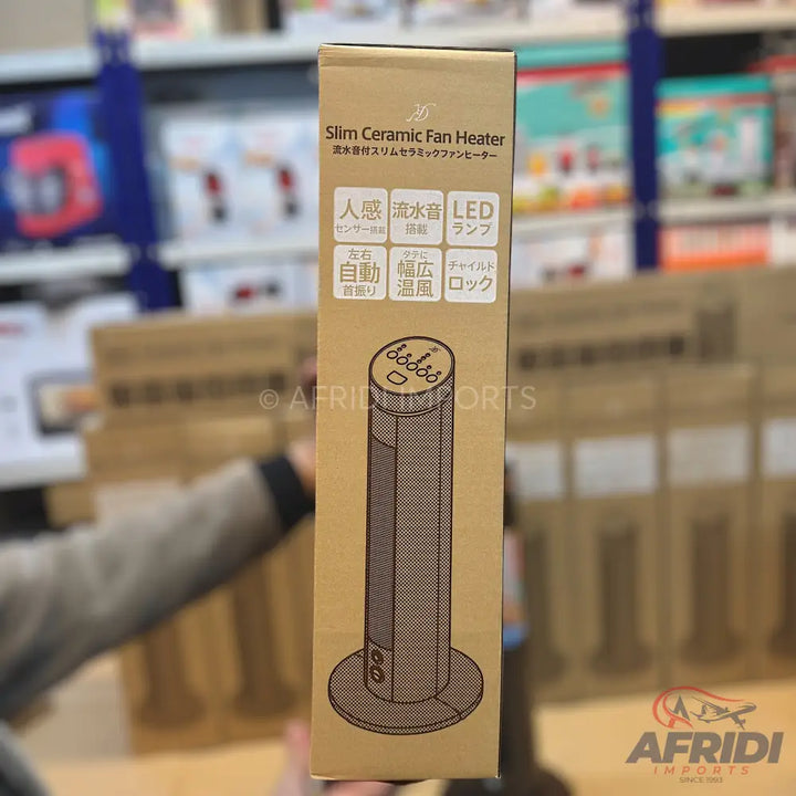 A slim, cylindrical ceramic fan heater in a cardboard box.