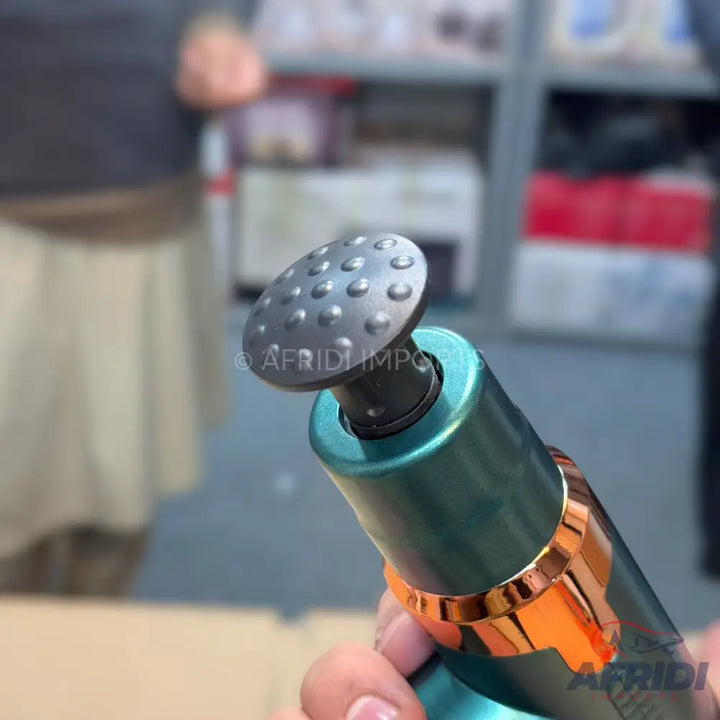 A teal and rose gold handheld massage gun with a mushroom-shaped, textured attachment.