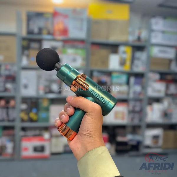 A handheld teal and copper massage gun with a spherical black attachment.