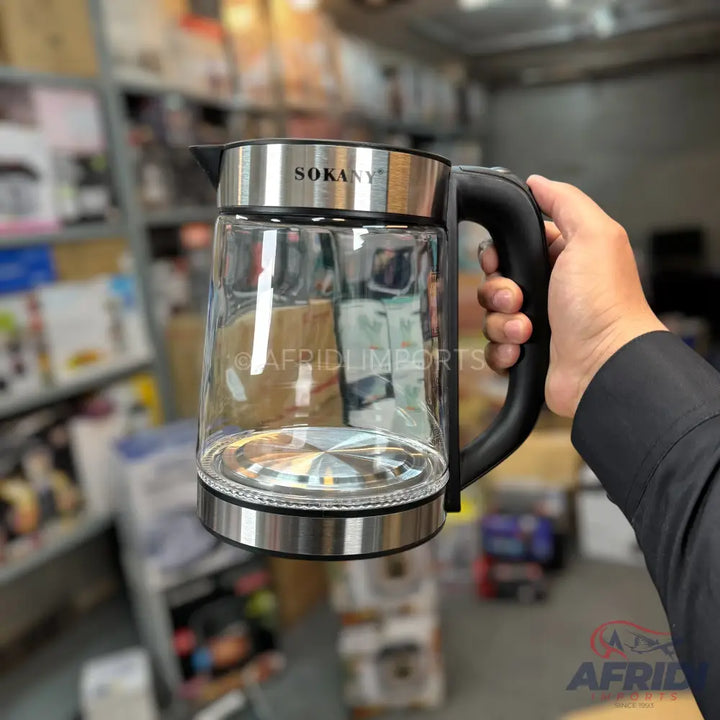 Glass electric kettle with a black handle and stainless steel accents.