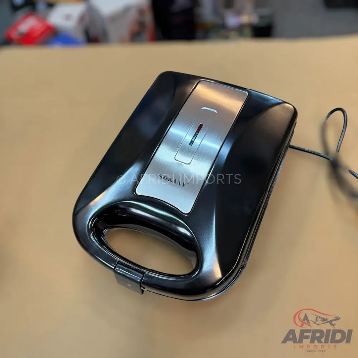 Black electric sandwich maker with a silver-toned top panel and indicator lights.