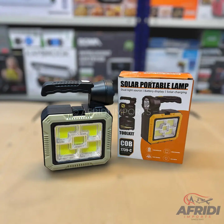 A solar portable lamp with a top handle, a flashlight on one side, and a large multi-LED panel on the other.