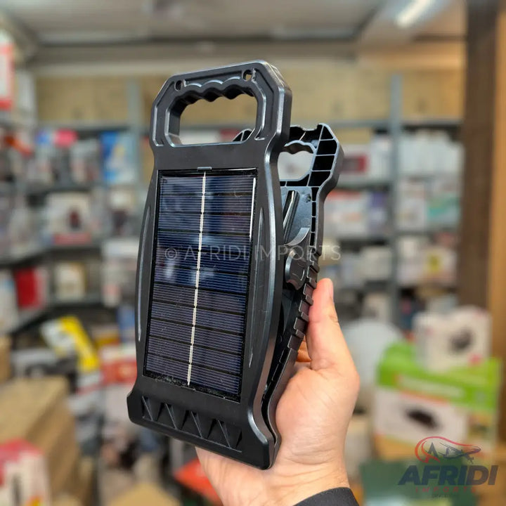 Black solar-powered portable lantern with a handle.
