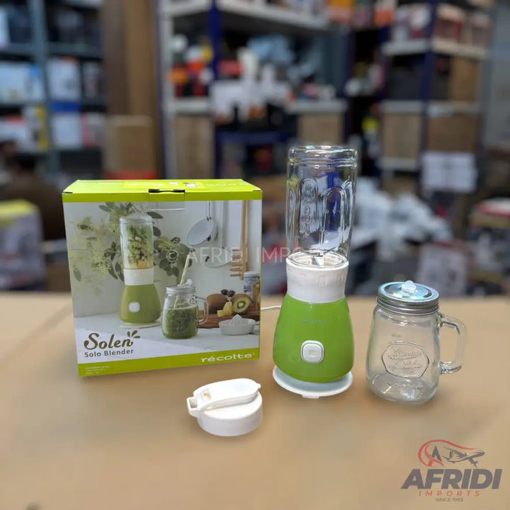 Green and white personal blender with a clear blending cup, a separate mason jar-style drinking cup, and a lid.