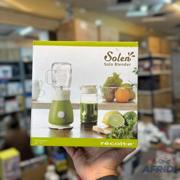A green and white solo blender with a glass jar, suitable for making smoothies or juices.