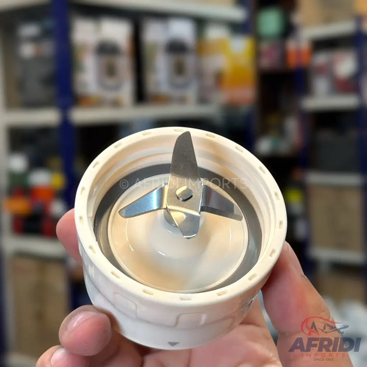 A blender blade assembly with a four-pronged metal blade and a white plastic base.