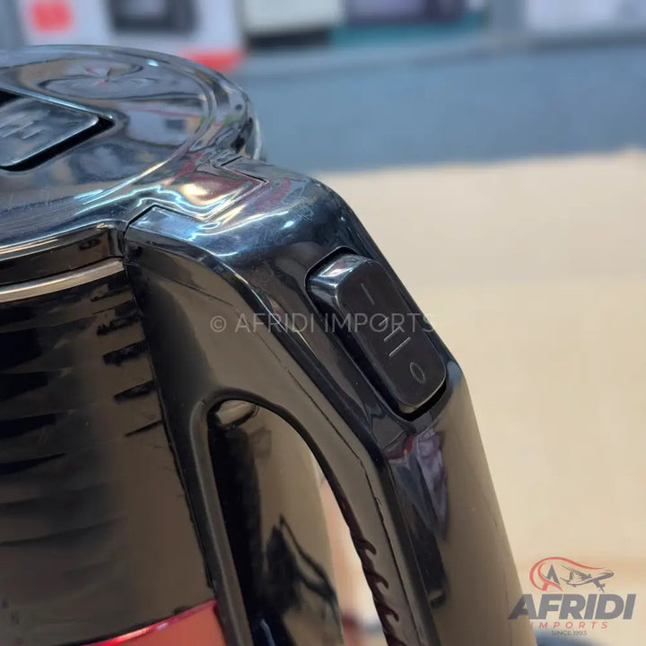 Black electric kettle with a transparent water level indicator and a red base.