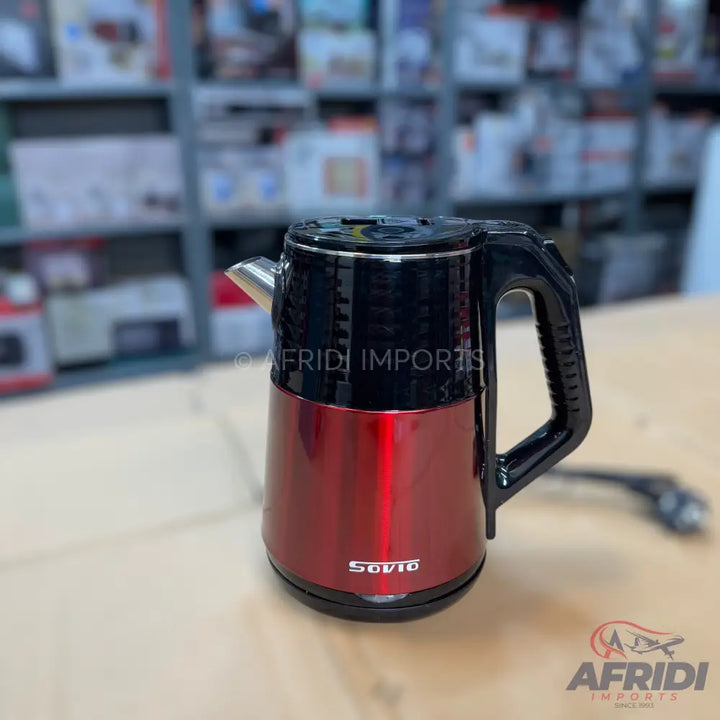 Red and black electric kettle with a handle and spout.