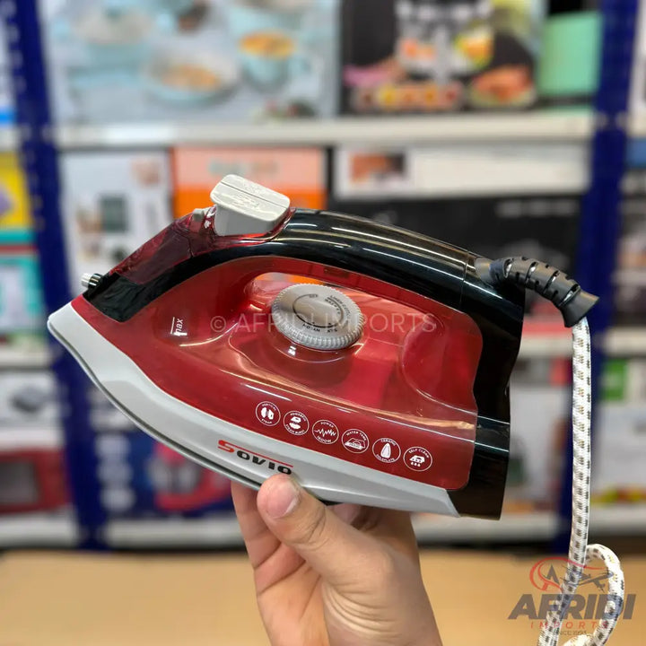 Red and black steam iron with a white base and a braided power cord.