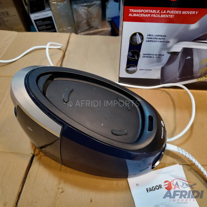 A compact, dark blue and silver portable steam iron with a white power cord.