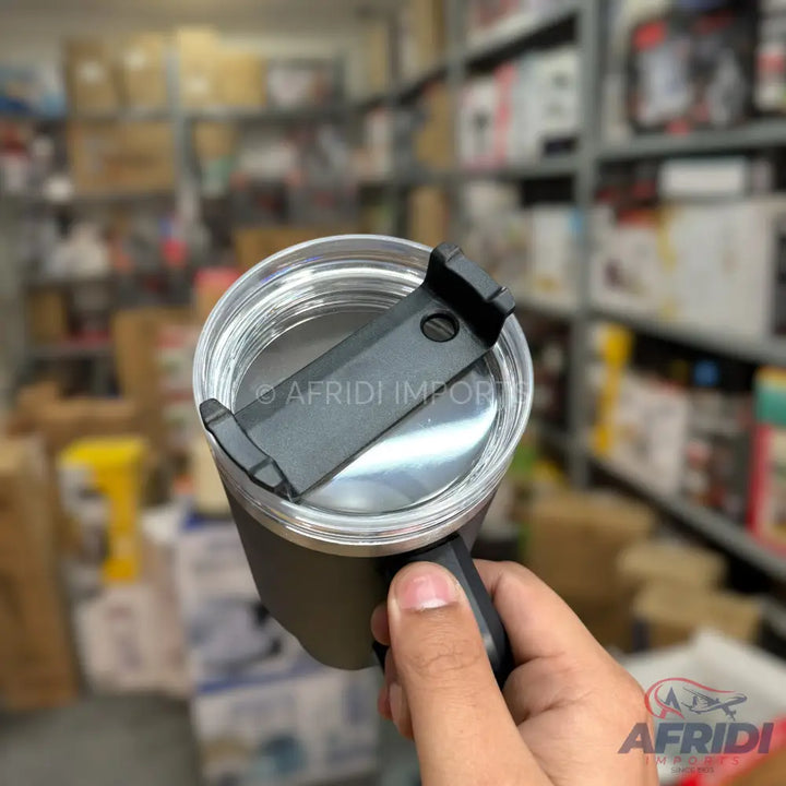 A stainless steel travel mug with a black, clear plastic lid.