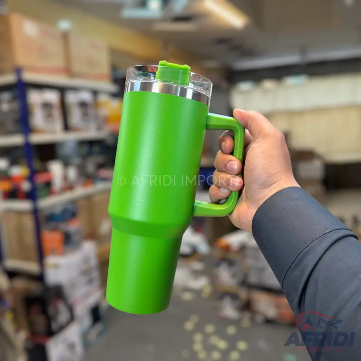 Green insulated travel mug with a handle and clear lid.