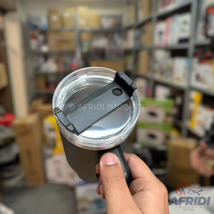 A black travel mug with a clear, flip-top lid.