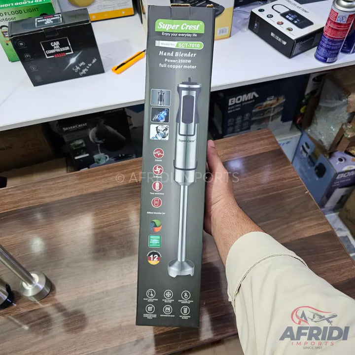 A boxed Super Crest hand blender with a 1000W full copper motor and 12-speed settings.