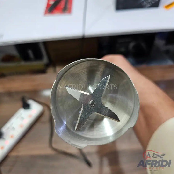 A hand blender with a four-pronged stainless steel blade.