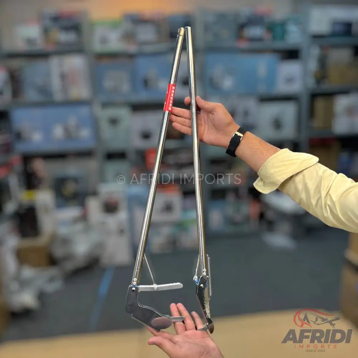 Stainless steel fruit picker tool with a spring-loaded gripping mechanism.