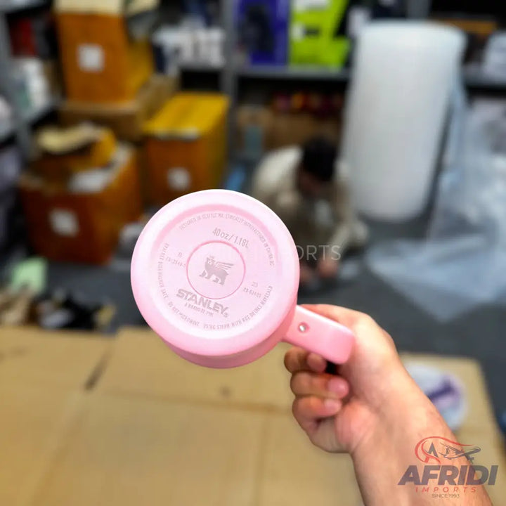Pink Stanley travel mug with a handle.