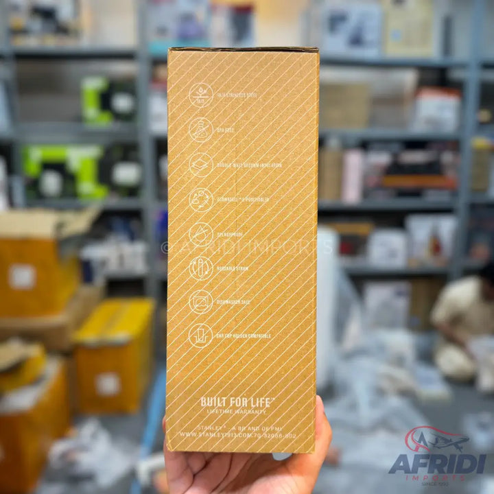 Brown cardboard box with white diagonal stripes and circular icons.