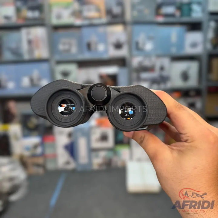 A pair of black binoculars with visible eyepieces and a central focusing knob.