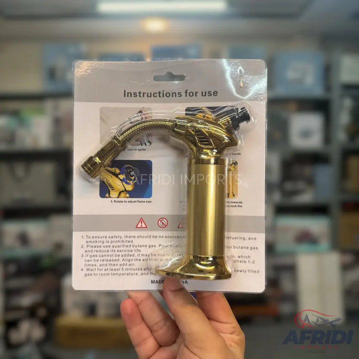 A new, golden-colored butane torch with an adjustable flame.