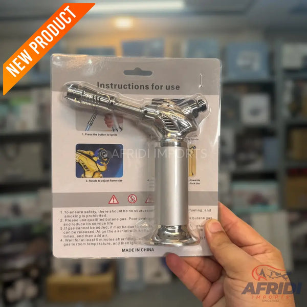 A chrome-plated butane torch in blister packaging.