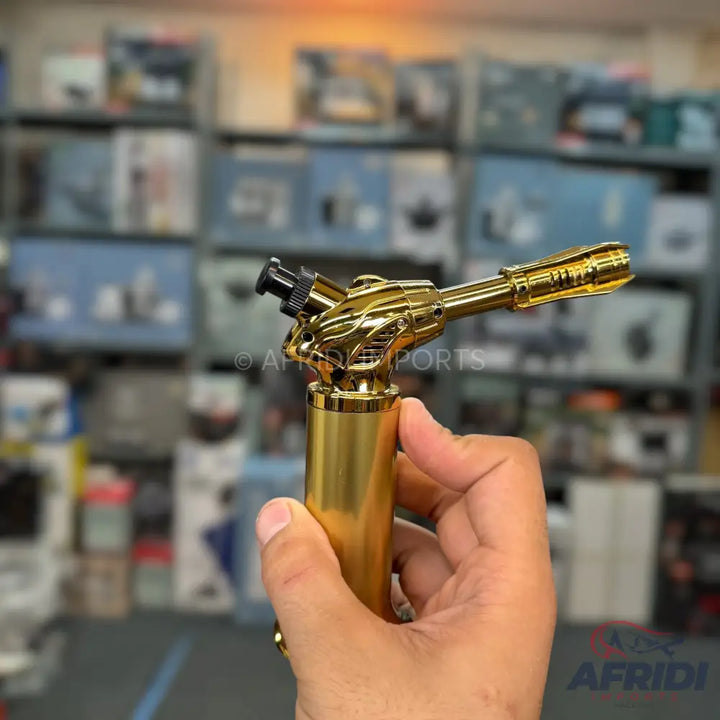 A gold-colored metal torch lighter with a dragon-shaped body.