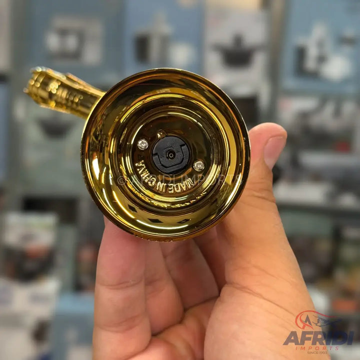 A shiny gold-colored metal component with an internal mechanism.