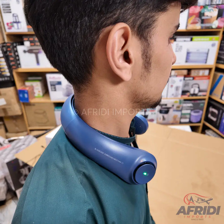 A blue, U-shaped, wearable neck fan with a green indicator light.
