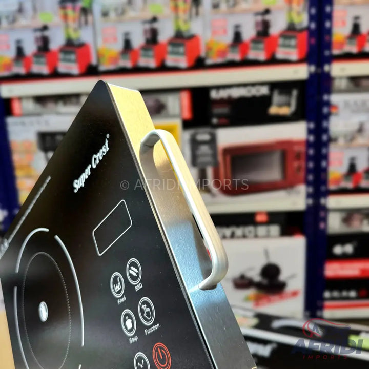 Black induction cooktop with digital controls and a silver handle.