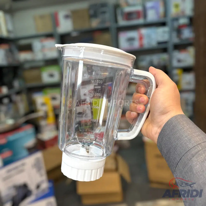 A clear plastic blender jar with a white lid, handle, and blade assembly.