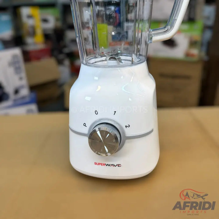 A white electric blender with a transparent pitcher and a silver control knob.