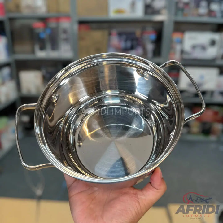 A shiny, stainless steel cooking pot with two handles.
