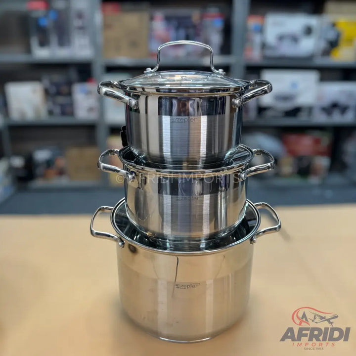 A three-piece set of nested stainless steel cooking pots with lids.