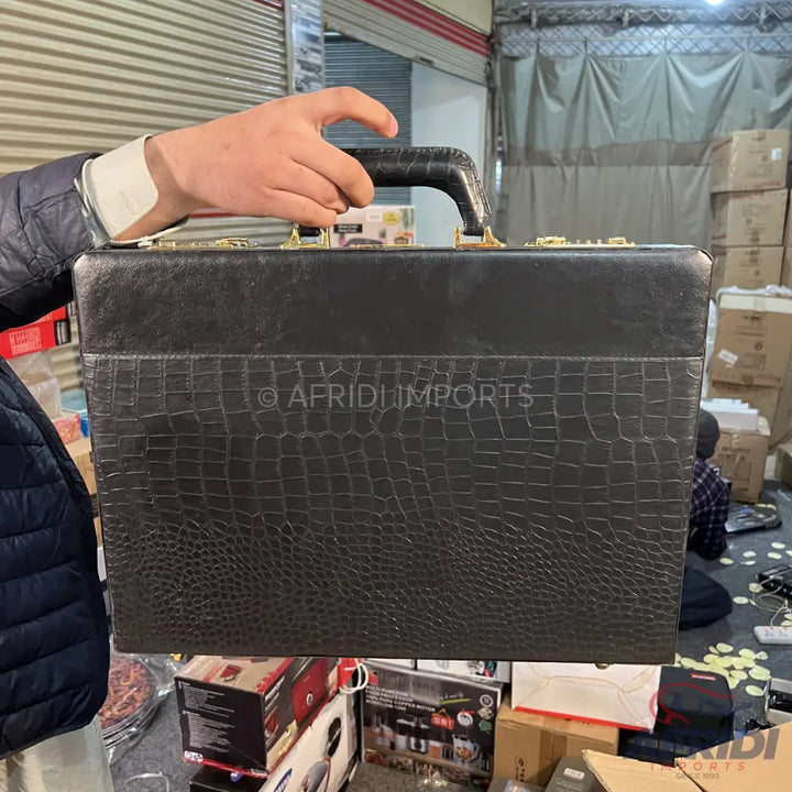 Black, crocodile-embossed briefcase with gold-toned hardware.