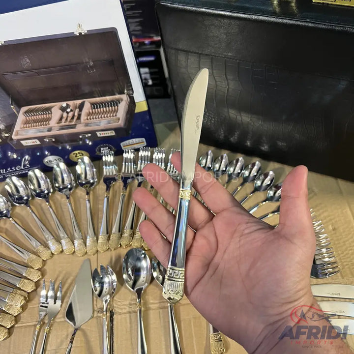 Silver and gold-colored flatware set in a dark brown case.