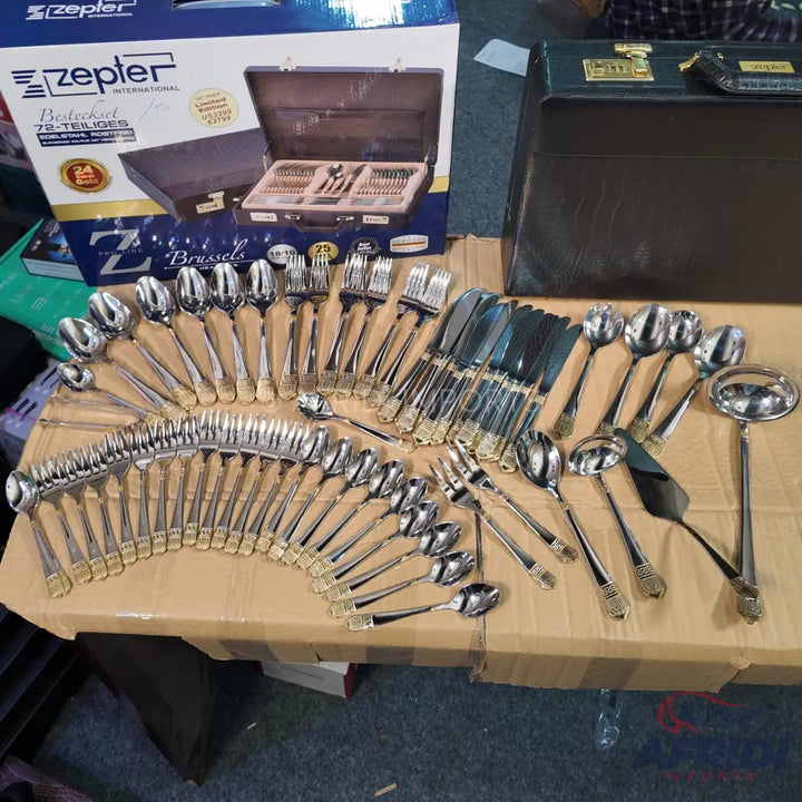 A comprehensive 72-piece Zepter stainless steel cutlery set with gold accents, including various spoons, forks, knives, and serving utensils.
