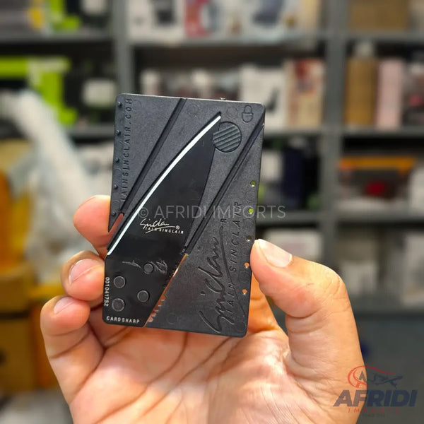A black credit card-sized folding knife.
