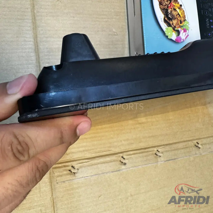 A black plastic remote control holder with a raised backrest.