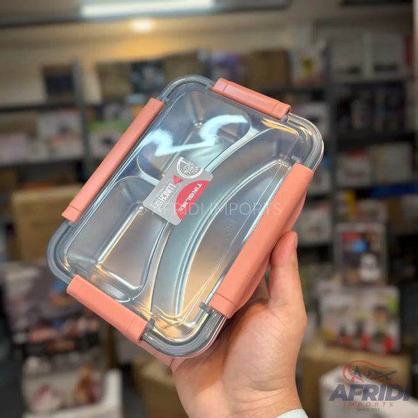 A multi-compartment stainless steel lunchbox with a clear lid and peach-colored latches.
