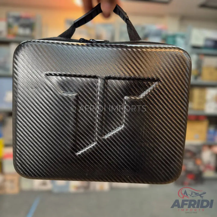 Black carbon fiber patterned hard case with an embossed logo and a fabric handle.
