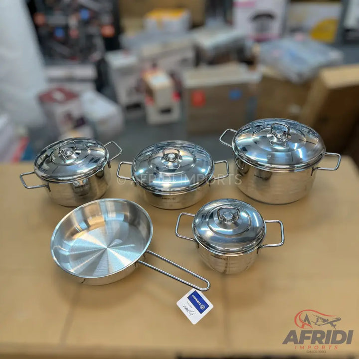 A set of five stainless steel pots and pans with lids and handles.