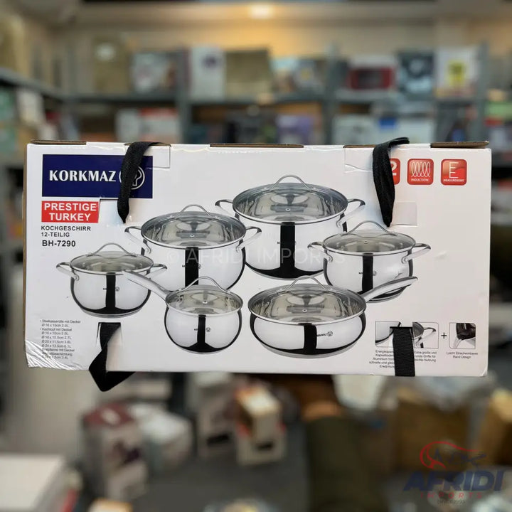 A boxed set of stainless steel pots and pans with glass lids.
